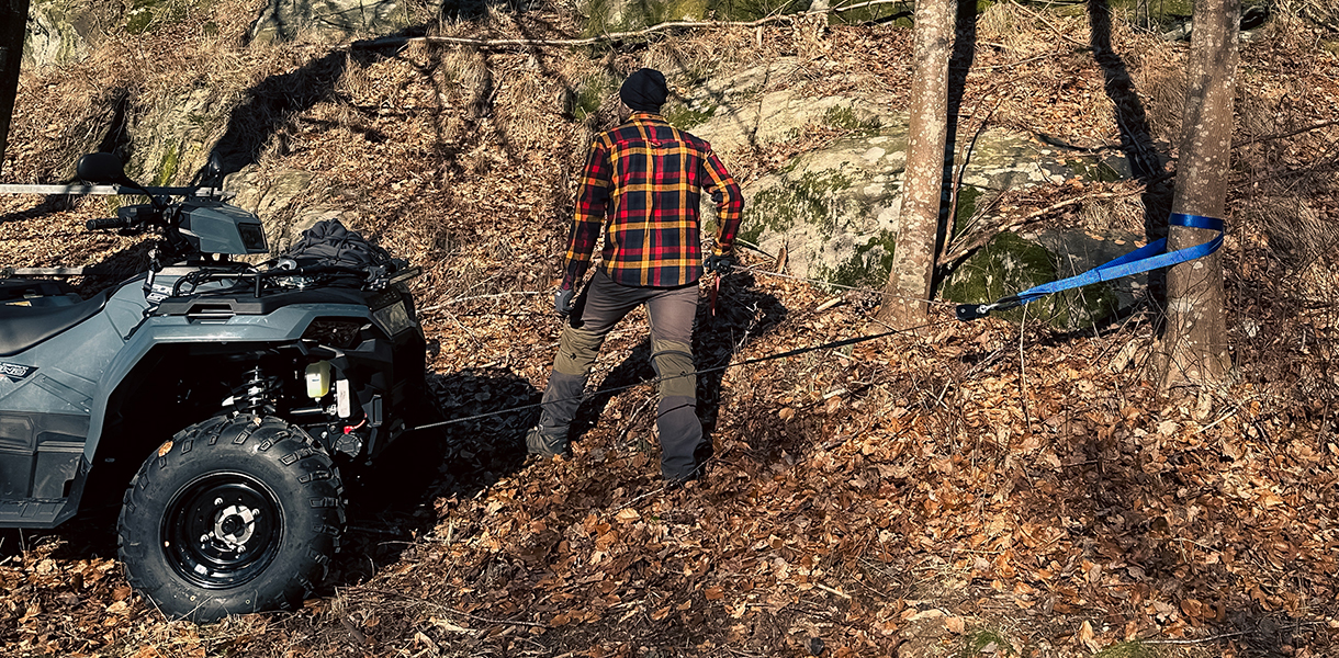 ATV med vinsch som används i terräng, linan utrullad