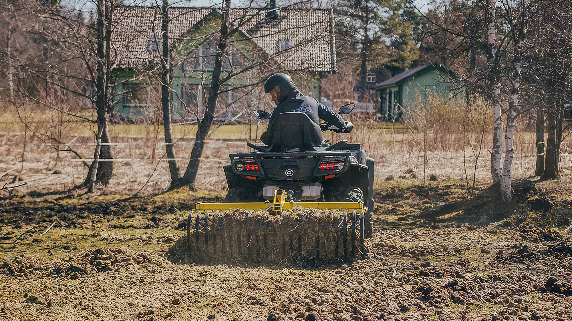 ATV med redskapsbärare och kratta på ridbana